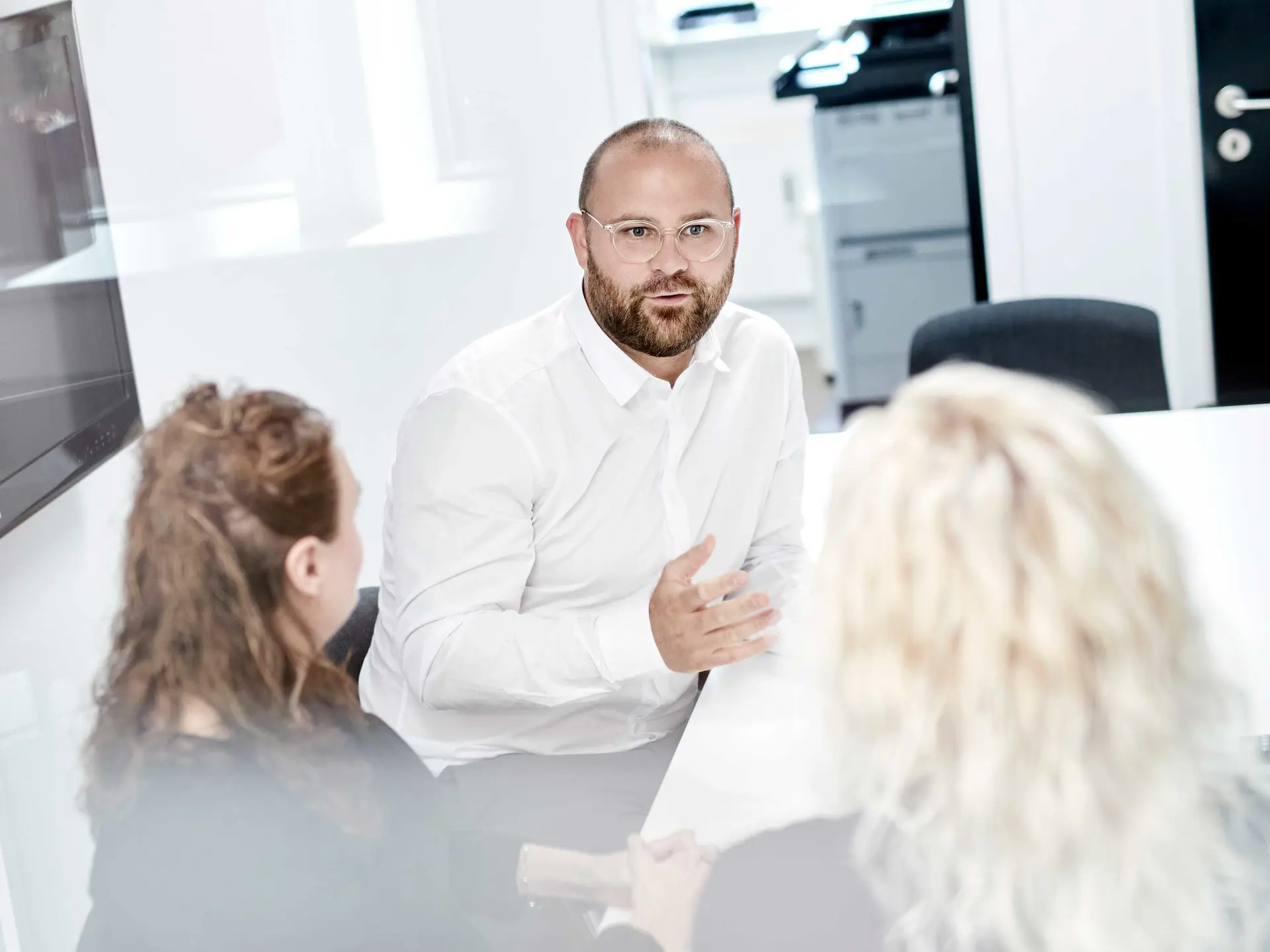 Rådgiver taler med kunder om deres muligheder for pensionsopsparing i Vestjysk Bank