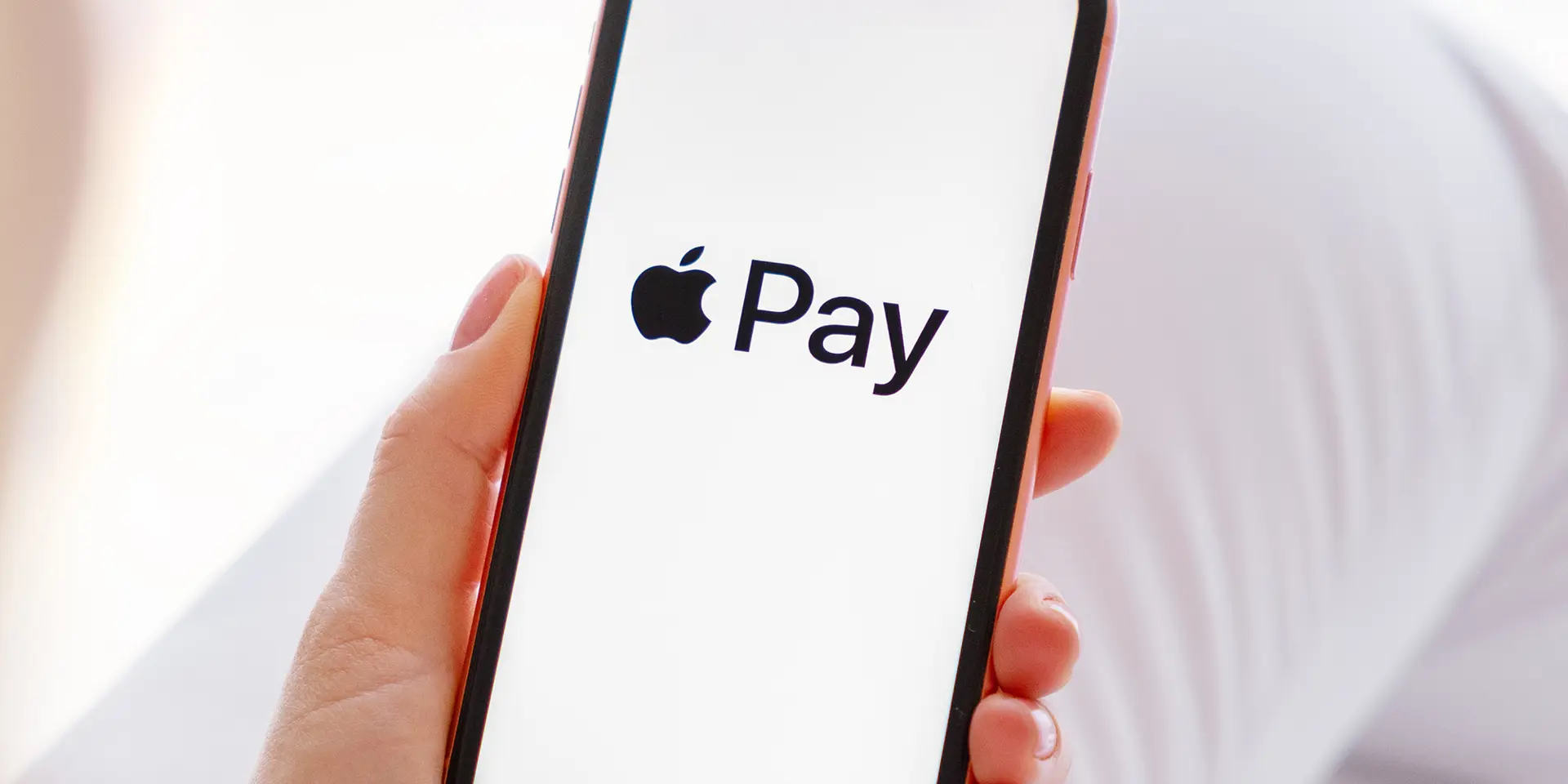 Kunde kigge på sin telefon hvor der står apple pay. 